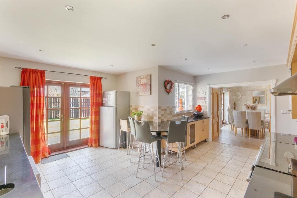 The kitchen at Alnside Lodge, with a breakfast bar and doors to the garden